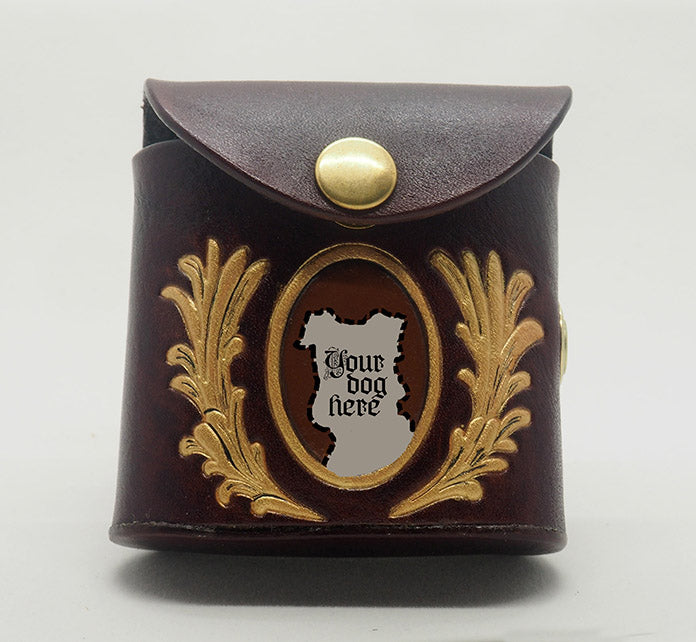 Mahogany leather dog waste bag dispenser with brass snap hardware. Design features a gold portrait frame with an umber colored background and the words "your dog here." The frame is wreathed in gold laurels.
