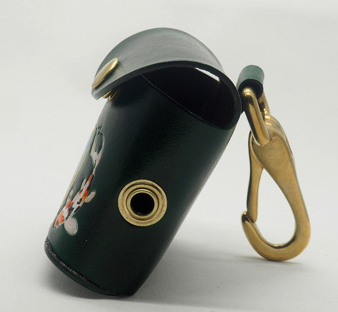 Green leather dog waste bag dispenser with brass snap hardware, shown from the side to display the brass grommet and solid brass halter-style snap.